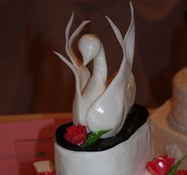 Högst uppe på toppen av den höga tårtan svävar svanen